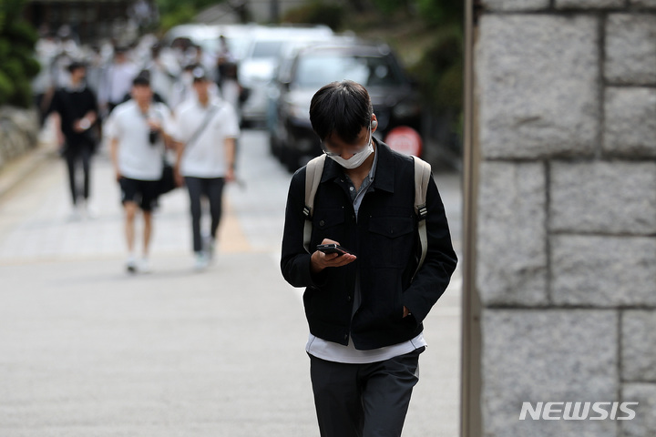 [서울=뉴시스] 백동현 기자 = 지난 2022년 5월25일 오후 서울 시내 한 중학교 앞에서 학생들이 스마트폰을 보면서 하교하고 있는 모습.2022.05.25. livertrent@newsis.com