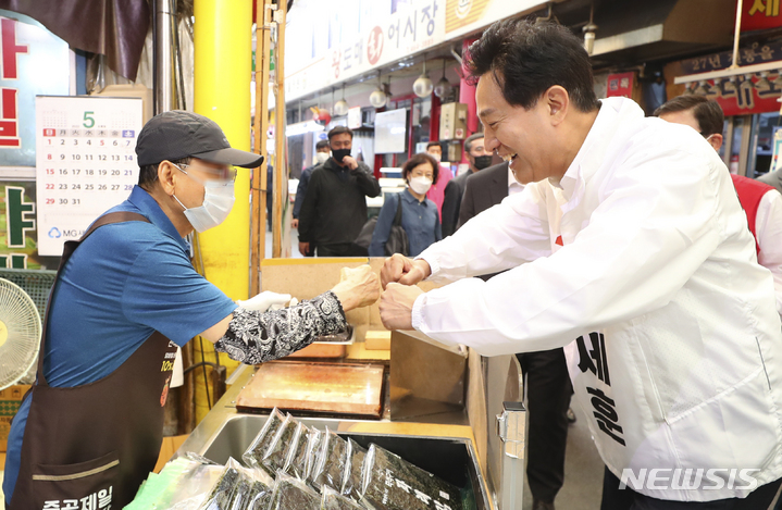 [서울=뉴시스] 최진석 기자 = 오세훈 국민의힘 서울시장 후보가 26일 오전 서울 광진구 중곡제일골목시장에서 김경호 광진구청장 후보와 선거 유세를 하며 상인과 인사를 나누고 있다. 2022.05.26. myjs@newsis.com