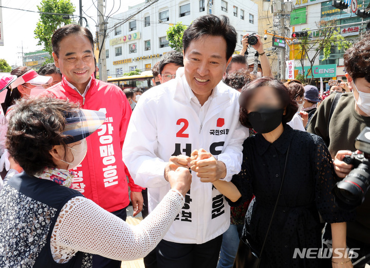 [서울=뉴시스] 국회사진기자단 = 오세훈 국민의힘 서울시장 후보가 26일 오전 서울 성동구 뚝섬로 성수전략지구에서 유세를 하며 시민들과 인사를 나누고 있다. 2022.05.26. photo@newsis.com