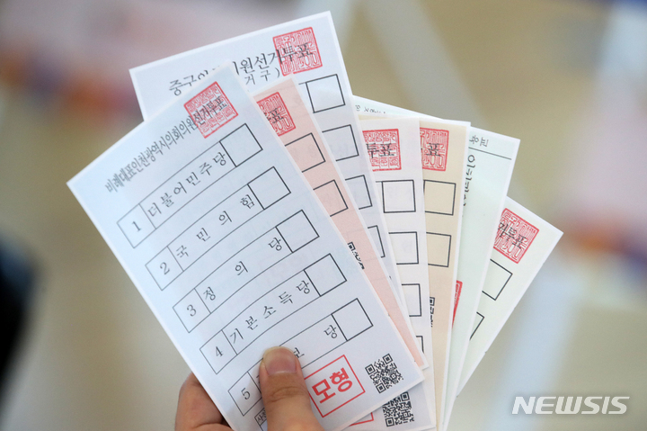 [인천공항=뉴시스] 조성우 기자 = 제8회 전국동시지방선거 사전투표를 하루 앞둔 26일 오후 인천국제공항 제1여객터미널에 설치된 사전투표소에서 인천 중구청 직원이 투표용지 모형을 들어 보이고 있다. 2022.05.26. xconfind@newsis.com