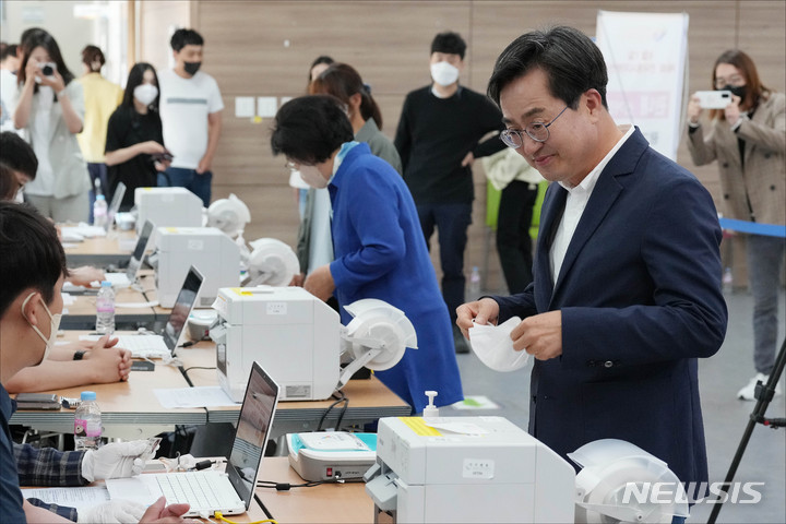[수원=뉴시스] 국회사진기자단 = 김동연 더불어민주당 경기도지사 후보가 27일 오전 경기도 수원시 영통구 광교1동 행정복지센터에 마련된 사전투표소에서 사전투표를 위해 본인 확인을 하고 있다. 2022.05.27. photo@newsis.com