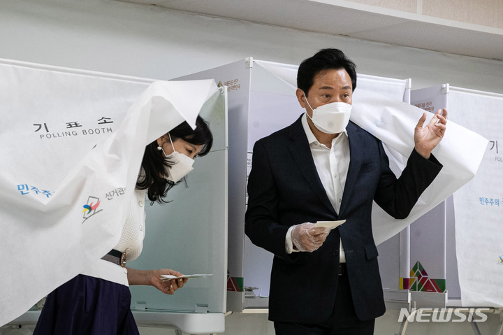 [서울=뉴시스] 국회사진기자단 = 오세훈 국민의힘 서울시장 후보가 부인 송현옥 세종대 교수와 함께 27일 오전 서울 광진구 자양3동 주민센터에 마련된 사전투표소에서 제8회 전국동시지방선거·국회의원 보궐선거 투표를 하고 있다. 2022.05.27. photo@newsis.com