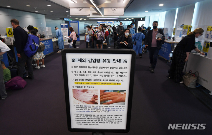 [인천공항=뉴시스] 최동준 기자 = 최근 해외에서 원숭이 두창 감염사례가 발생하고 있는 지난달 27일 오전 인천국제공항 제1여객터미널 입국장에서 독일 프랑크푸르트와 우즈베키스탄발 탑승객들이 검역을 받기 위해 대기하고 있는 가운데 원숭이 두창 안내문이 게시되어 있다. (공동취재사진) 2022.05.27. photo@newsis.com