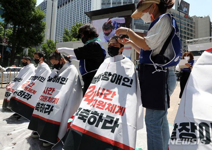 [서울=뉴시스] 이영환 기자 = 27일 오전 서울 중구 서울시청앞에서 열린 서울시 규탄 결의대회 '우리의 권리는 자라지 않았다, 고인이 된 발달장애인과 그 어머니를 추모하며 다시 머리를 밀어낸다' 참석자들이 삭발식을 하고 있다. 2022.05.27. 20hwan@newsis.com