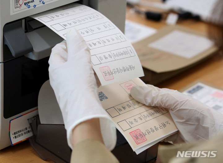 [서울=뉴시스] 김진아 기자 = 제8회 전국동시지방선거 사전투표 첫날인 지난 27일 서울 성북구 시립성북청소년센터에 마련된 장위제3동 사전투표소에서 사전투표사무원이 투표용지를 출력하고 있다. 2022.05.31. bluesoda@newsis.com