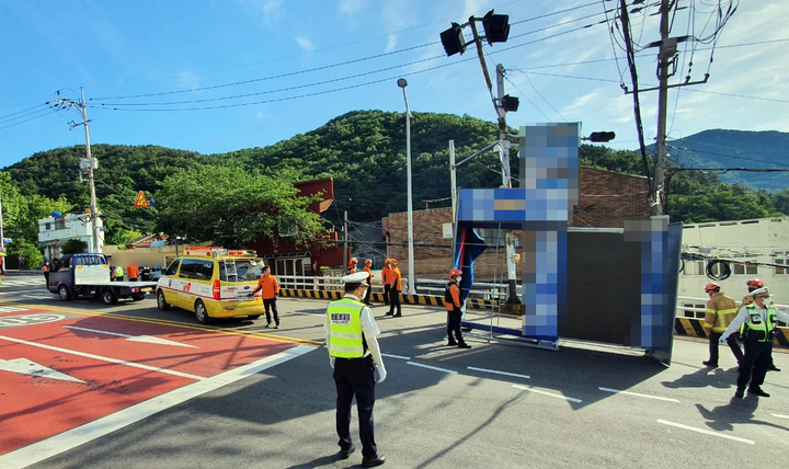 [부산=뉴시스] 29일 부산 서구의 한 도로를 지나던 지방선거 유세차량(1t)의 적재함에 실려 있던 구조물이 전선에 걸려 도로로 떨어졌다. (사진=부산소방재난본부 제공) *재판매 및 DB 금지