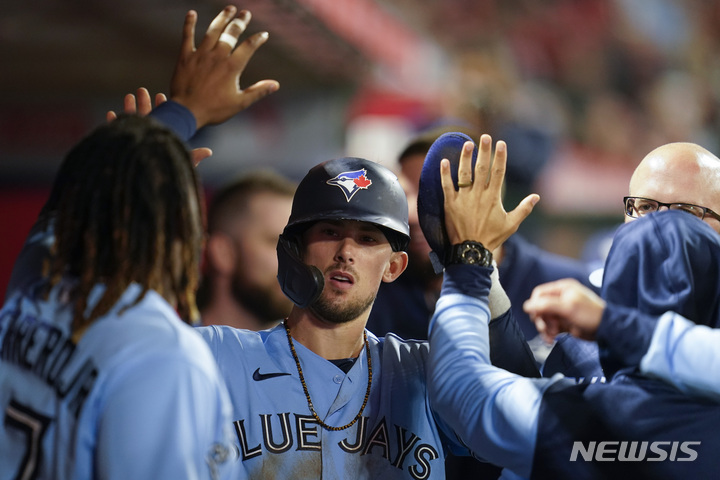 [LA=AP/뉴시스] 토론토 블루제이스의 캐번 비지오(가운데)가 29일(한국시간) 미국 캘리포니아주 애너하임의 에인절 스타디움에서 열린 LA 에인절스와 2022 MLB 원정경기에서 7회초 알레한드로 커크의 적시타로 홈을 밟은 뒤 덕아웃에서 동료들과 하이파이브를 나누고 있다. 2022.05.29.