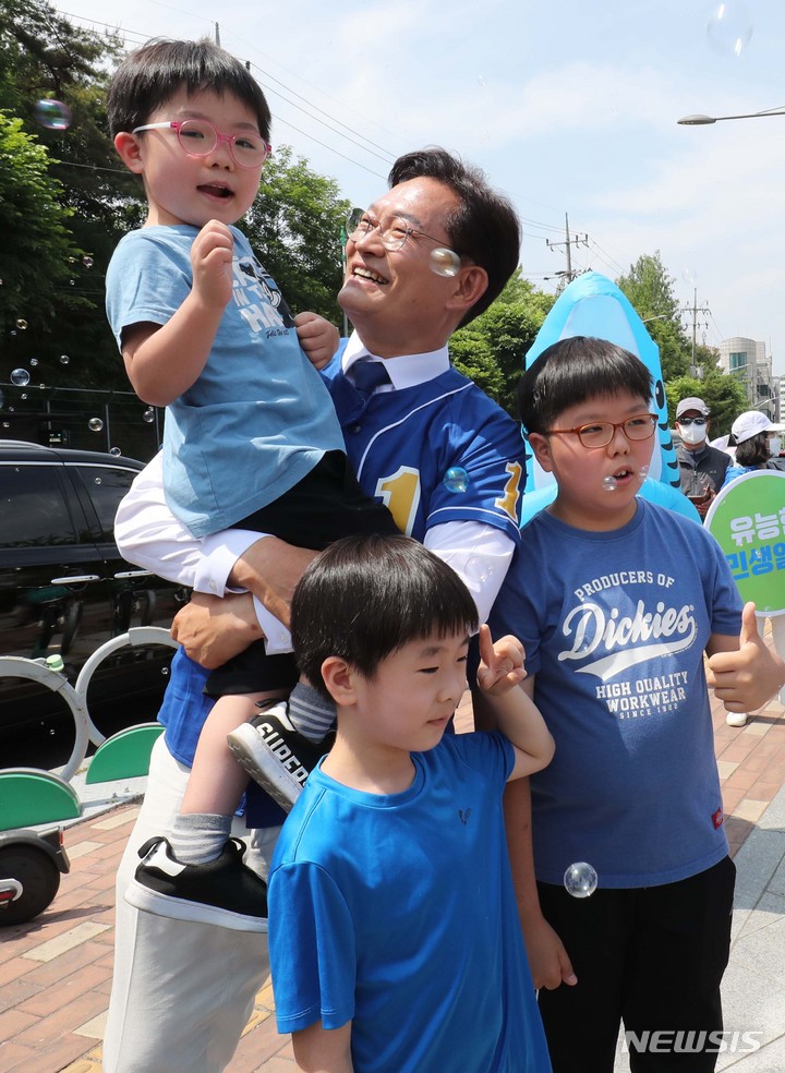 [서울=뉴시스] 국회사진기자단 = 송영길 더불어민주당 서울시장 후보가 29일 서울 강북구 북서울꿈의숲에서 유세 중 어린이들과 기념촬영을 하고 있다. 2022.05.29. photo@newsis.com