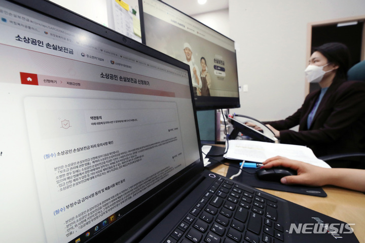 [서울=뉴시스] 김진아 기자 = 30일 서울 종로구 소상공인시장진흥공단 서울중부센터에서 직원들이 소상공인 손실보전금 관련 업무를 하고 있다. 중소벤처기업부는 이날 정오부터 손실보전금 신청을 받아 총 23조원 규모의 소상공인 손실보전금을 지급한다고 밝혔다. 코로나19 방역 조치로 피해를 입은 소상공인·자영업자 371만명은 1인당 600만원에서 최대 1000만원까지 손실보전금을 수령할 수 있게 됐다. 2022.05.30. bluesoda@newsis.com