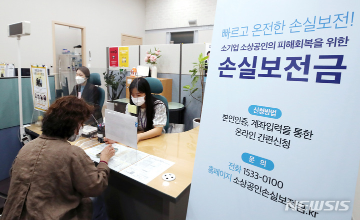 [서울=뉴시스] 김진아 기자 = 30일 서울 종로구 소상공인시장진흥공단 서울중부센터에서 자영업자가 소상공인 손실보전금 관련 상담을 받고 있다. 중소벤처기업부는 이날 정오부터 손실보전금 신청을 받아 총 23조원 규모의 소상공인 손실보전금을 지급한다고 밝혔다. 코로나19 방역 조치로 피해를 입은 소상공인·자영업자 371만명은 1인당 600만원에서 최대 1000만원까지 손실보전금을 수령할 수 있게 됐다. 2022.05.30. bluesoda@newsis.com