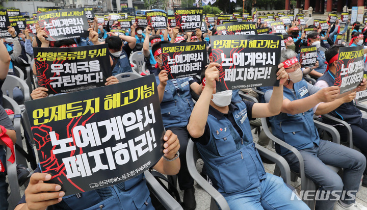 [서울=뉴시스] 권창회 기자 = 전국택배노조 소속 회원들이 지난달 30일 오후 서울 종로구 보신각 공원 인근에서 열린 우체국본부 전국 간부결의대회에서 구호를 외치고 있다. 2022.05.30. kch0523@newsis.com