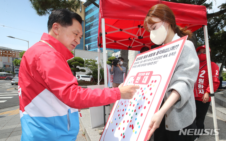[제주=뉴시스] 우장호 기자 = 김기현 국민의힘 공동선거대책위원장이 30일 오후 제주시청 조형물 앞에서 열린 '김포공항 이전 폐지 규탄 서명운동'에 참석해 이전 반대란에 스티커를 붙이고 있다. 2022.05.30. woo1223@newsis.com