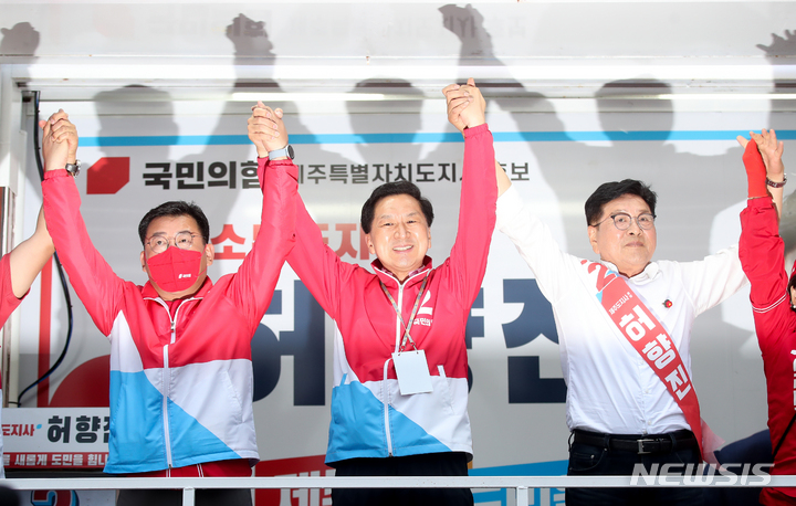 [제주=뉴시스] 우장호 기자 = 30일 오후 제주시 노형동 롯데마트 인근 사거리에서 진행된 총력 유세에서 김기현(가운데) 국민의힘 공동선거대책위원장이 차량에 올라 허향진(오른쪽) 제주도지사 후보와 손을 맞잡고 유권자들에게 인사하고 있다. 2022.05.30. woo1223@newsis.com