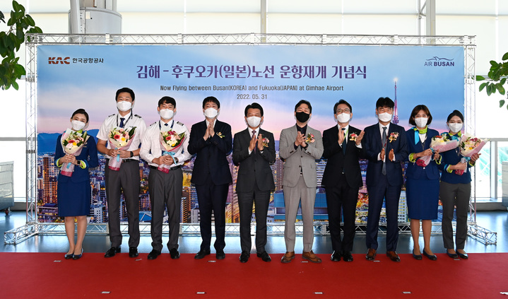 [서울=뉴시스] 홍찬선 기자 = 윤형중(왼쪽에서 여섯번째) 한국공항공사 사장이 31일 오전 김해공항에서 열린 일본 후쿠오카 노선 운항재개 기념식에 참석해 참석자들과 기념촬영을 하고 있다. (사진=한국공항공사 제공) 2022.05.31. photo@newsis.com *재판매 및 DB 금지