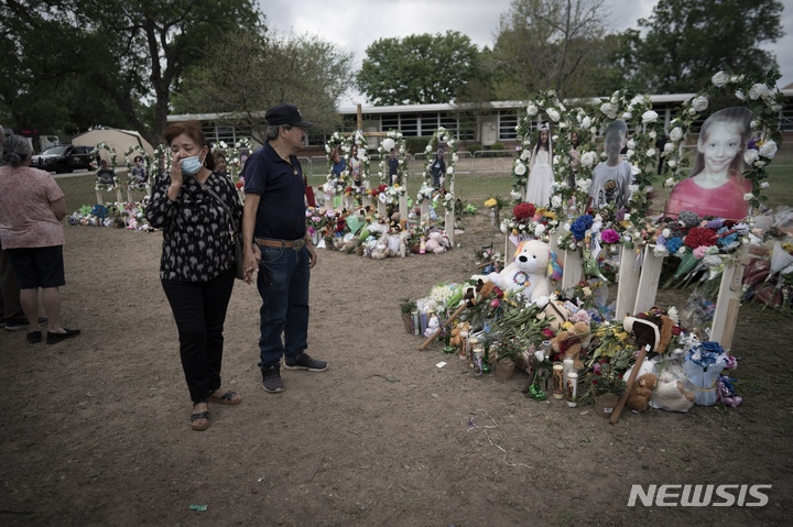 [유밸디( 미 텍사스주)= AP/뉴시스] 총격사건으로 19명이 숨진 텍사스주의 초등학교 앞 추모의 장소에 어린이들의 사진과 추모객들의 꽃다발, 장난감이 남겨져 있다.   