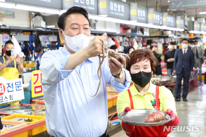 [부산=뉴시스] 홍효식 기자 = 윤석열 대통령이 31일 부산 중구 자갈치시장을 방문해 낙지를 들어 보이고 있다. 2022.05.31. yesphoto@newsis.com