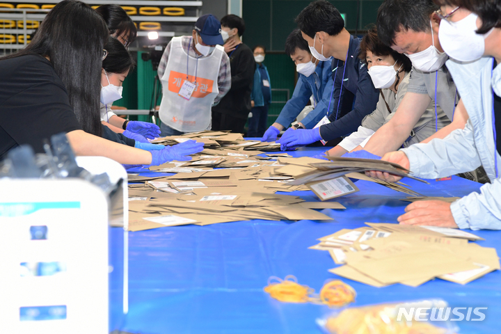 [남해=뉴시스] 차용현 기자 = 제8회 전국동시지방선거가 실시된 1일 오후 경남 남해군 남해실내체육관에 마련된 개표소에서 개표원들이 관외투표함을 열고 개표를 준비하고 있다. 2022.06.01. con@newsis.com