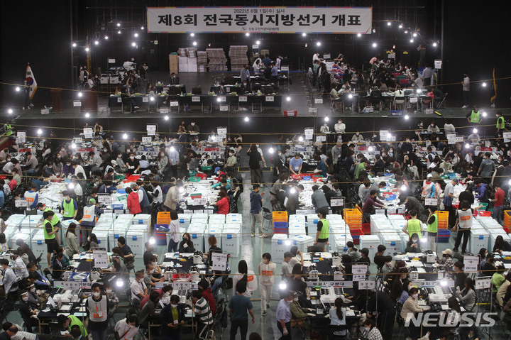 [서울=뉴시스] 권창회 기자 = 제8회 전국동시지방선거일인 1일 오후 서울 강동구 올림픽공원 내 올림픽홀에 마련된 개표소에서 관계자들이 개표하고 있다. 2022.06.01. kch0523@newsis.com