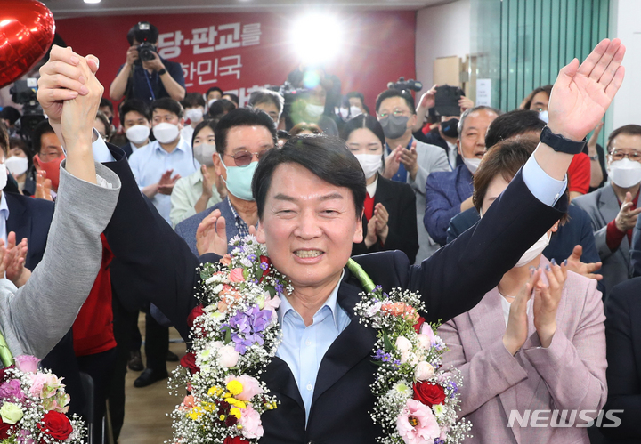 [성남=뉴시스] 경기사진공동취재단 = 안철수 국민의힘 성남 분당갑 후보가 제8회 전국동시지방선거 투표일인 1일 오후 경기 성남시 분당구 야탑역 인근에 위치한 선거사무소에서 당선이 확실시 되자 꽃다발을 목에 걸고 환호하고 있다. 2022.06.01. photo@newsis.com