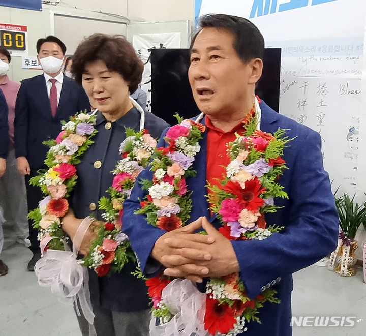 [양산=뉴시스] 안지율 기자 = 제8회 전국동시 지방선거일인 1일 오후 국민의힘 나동연 경남 양산시장 후보가 자신의 선거캠프에서 당선이 확실해지자 부인 정희자 여사와 함께 꽃목걸이를 걸고 소감을 밝히고 있다. 2022.06.01. alk9935@newsis.com
