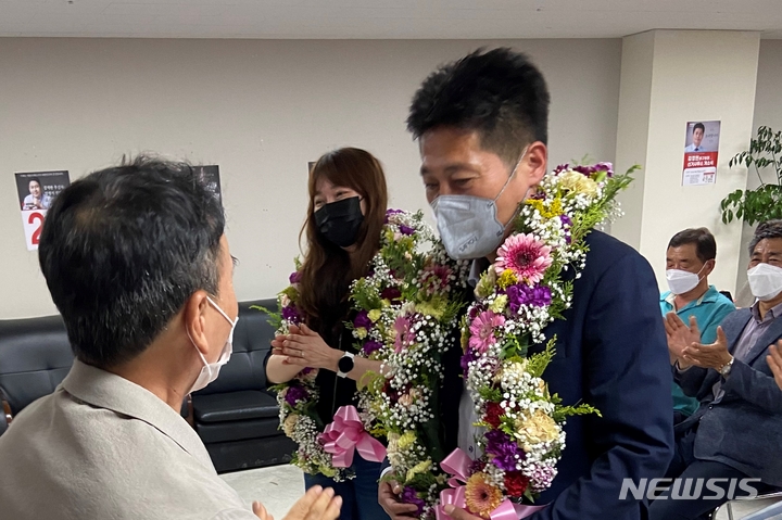 [인천=뉴시스] 이루비 기자 = 김정헌 인천 중구청장 당선자가 꽃목걸이를 받고 있다. 2022.06.02. (사진=김정헌 선거사무소 제공)