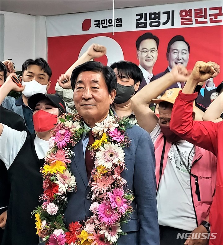 [횡성=뉴시스] 이덕화 기자 = 2일 새벽 축하 꽃다발을 건네 받은 김명기 국민의힘 횡성군수 당선인이 당원·지지자들에게 승리의 환호를 받으며 미소를 짖고 있다. 2022.06.02. wonder8768@newsis.com