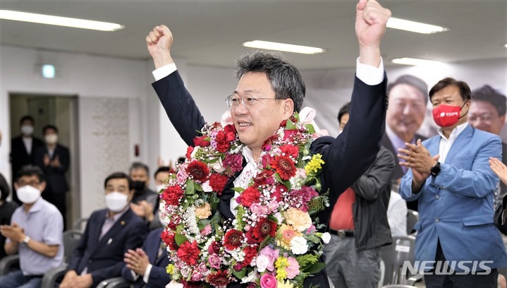 [원주=뉴시스] 이덕화 기자 = 박정하 국민의힘 원주갑 국회의원 당선인이 축하 꽃다발을 받은 후 당원·지지자들의 환호와 박수를 받으며 두팔을 들고 승리를 자축하고 있다. 2022.06.02. wonder8768@newsis.com 