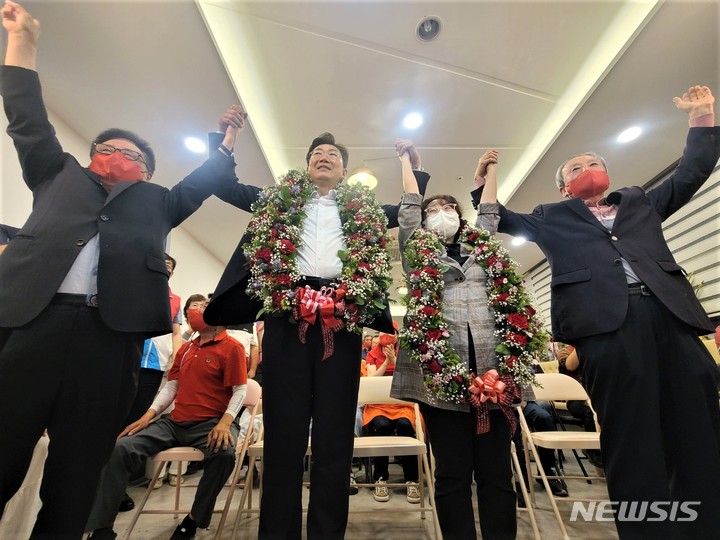 [원주=뉴시스] 이덕화 기자 = 원강수 국민의힘 원주시장 당선인이 축하 꽃다발을 받은 후 당원·지지자들의 환호와 박수를 받으며 두팔을 들고 승리를 자축하고 있다. 2022.06.02. wonder8768@newsis.com 