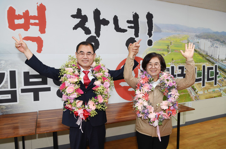 [창녕=뉴시스] 안지율 기자 = 제8회 전국동시 지방선거일인 2일 오전 국민의힘 김부영 경남 창녕군수 후보가 자신의 선거캠프에서 당선이 확실하자 부인과 함께 꽃목걸이를 걸고 기뻐하고 있다. (사진=김부영 후보 캠프 제공) 2022.06.02. photo@newsis.com *재판매 및 DB 금지