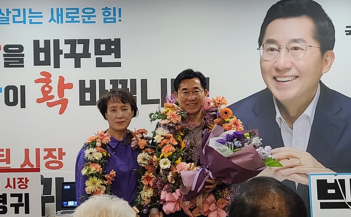 [아산=뉴시스] 이종익 기자 = 박경귀 국민의힘 아산시장 후보가 2일 오전 당선이 유력해지자 부인과 함께 꽃다발을 목에 걸고 인사말을 하고 있다. 200.06.02. 007news@newsis.com *재판매 및 DB 금지
