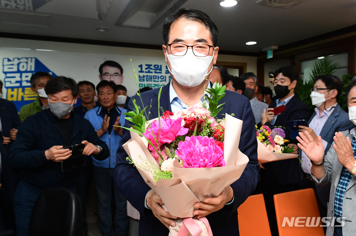 [남해=뉴시스] 차용현 기자 = 1일 오후 더불어민주당 장충남 남해군수 후보가 경남 남해군 남해읍 소재 자신의 선거사무소에서 제8회 전국동시지방선거 당선이 확실시되자 꽃다발을 들고 지지자들과 환호하고 있다. 2022.06.02. con@newsis.com