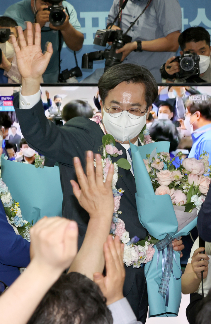[수원=뉴시스] 경기사진공동취재단 = 김동연 더불어민주당 경기도지사 당선인이 2일 오전 경기도 수원시 팔달구 선거사무소에서 꽃다발을 들고 환호하고 있다. 2022.06.02. photo@newsis.com