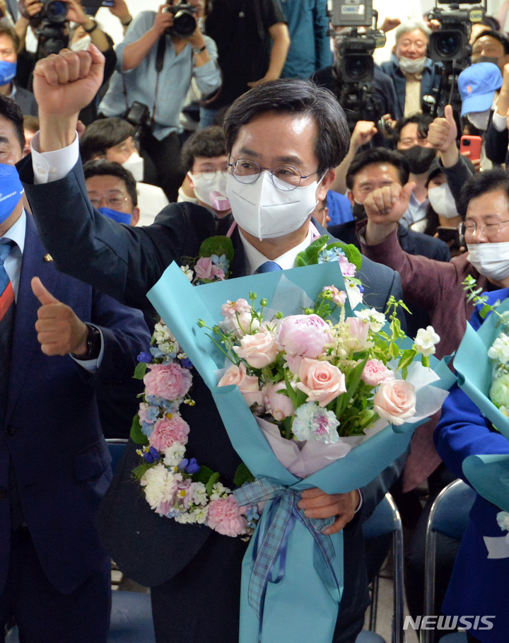 [수원=뉴시스] 경기사진공동취재단 = 김동연 더불어민주당 경기도지사 후보가 2일 오전 경기도 수원시 팔달구 선거사무소에서 당선이 확실시되자 꽃다발을 들고 환호하고 있다. 2022.06.02. photo@newsis.com