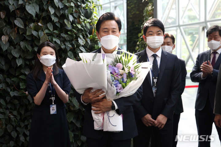 [서울=뉴시스] 김진아 기자 = '4선 서울시장'에 오른 오세훈 시장이 2일 오전 서울시청으로 출근을 하며 직원들에게 꽃다발을 받고 있다. 2022.06.02. blueosda@newsis.com