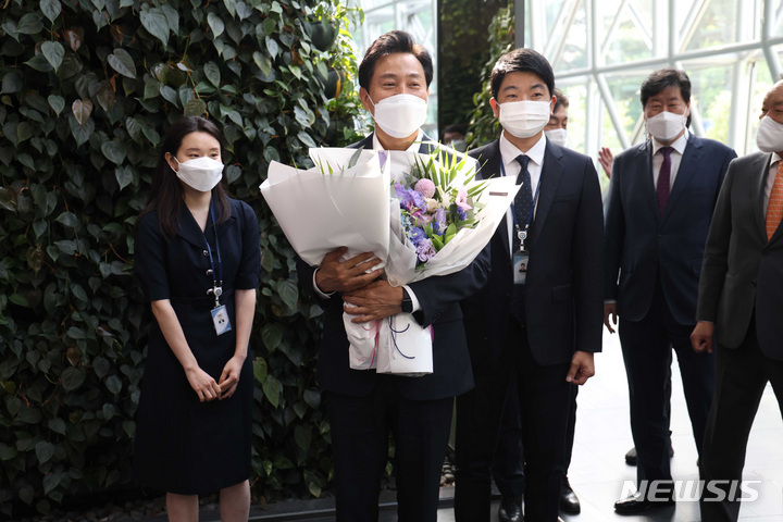 [서울=뉴시스] 김진아 기자 = '4선 서울시장'에 오른 오세훈 시장이 2일 오전 서울시청으로 출근을 하며 직원들에게 꽃다발을 받고 있다. 2022.06.02. blueosda@newsis.com