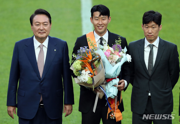 [서울=뉴시스] 이영환 기자 = 윤석열 대통령이 2일 오후 서울 마포구 서울월드컵경기장에서 진행되는 하나은행 초청 친선경기 대한민국과 브라질의 경기에 앞서 손흥민에게 체육 훈장인 청룡장을 수여한 후 기념촬영을 하고 있다. 2022.06.02. 20hwan@newsis.com