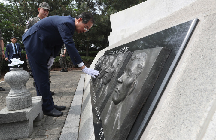 [평택=뉴시스] 추상철 기자 = 한덕수 국무총리가 4일 오전 경기 평택시 해군 2함대사령부에서 제2연평해전 전적비를 참배한 후 전사자 부조상을 어루만지고 있다. 2022.06.04. scchoo@newsis.com