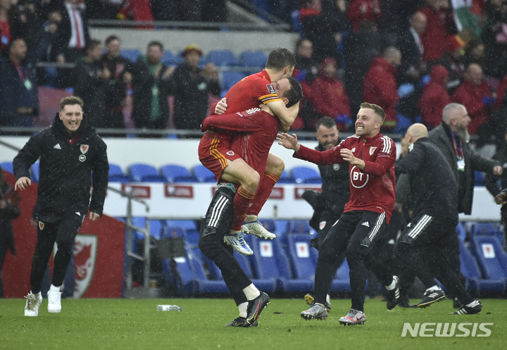 [카디프=AP/뉴시스] 웨일스 선수들이 6일(한국시간) 영국 웨일스 카디프의 카디프 스타디움에서 열린 우크라이나와 2022 FIFA 카타르 월드컵 유럽지역 예선 플레이오프 결승전에서 1-0으로 이기고 64년만의 월드컵 본선 진출을 확정한 뒤 기쁨을 나누고 있다. 2022.06.06.