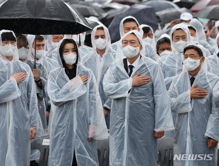 [서울=뉴시스] 전신 기자 = 윤석열 대통령과 부인 김건희 여사가 6일 서울 동작구 국립서울현충원에서 열린 제67회 현충일 추념식에서 국기에 대한 경례를 하고 있다. (대통령실통신사진기자단). 2022.06.06. photo1006@newsis.com