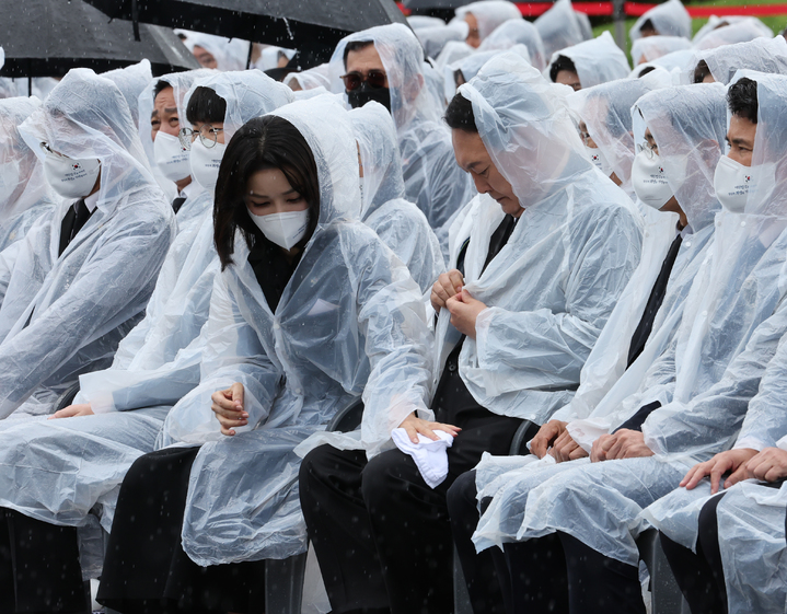 [서울=뉴시스] 전신 기자 = 윤석열 대통령의 부인인 김건희 여사가 6일 서울 동작구 국립서울현충원에서 열린 제67회 현충일 추념식에 참석해 윤 대통령의 옷의 빗물을 닦아주고 있다. (대통령실통신사진기자단). 2022.06.06. photo1006@newsis.com