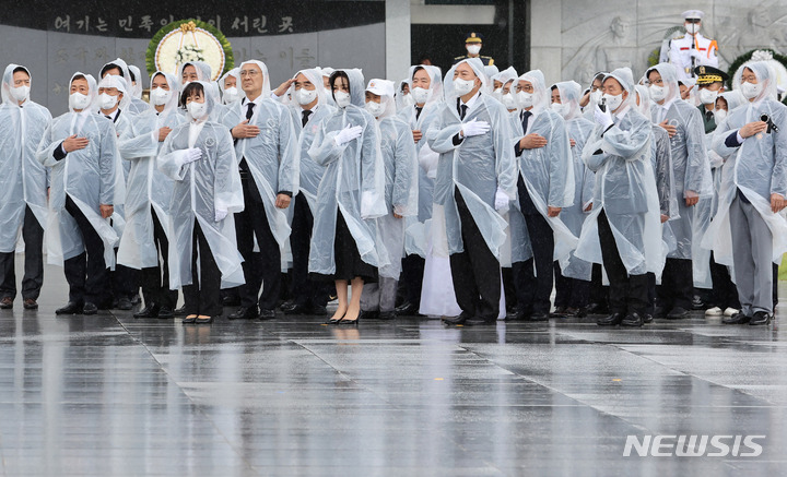[서울=뉴시스] 전신 기자 = 윤석열 대통령과 부인 김건희 여사가 6일 서울 동작구 국립서울현충원에서 열린 제67회 현충일 추념식에 참석해 현충탑 참배를 마친 후 이동하며 국기에 대한 경례를 하고 있다. (대통령실통신사진기자단) 2022.06.06. photo1006@newsis.com