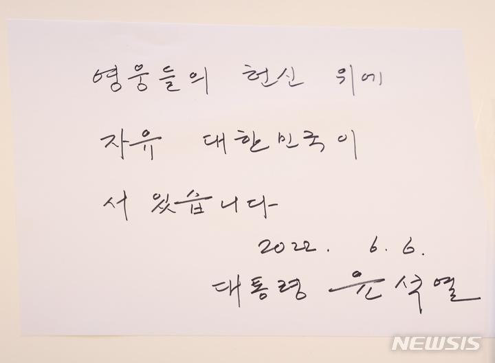 [서울=뉴시스] 윤석열 대통령은 6일 서울 강동구 중앙보훈병원을 방문해 입원 치료 중인 한 국가유공자의 사인 요청에 '영웅들의 헌신 위에 자유 대한민국이 서 있습니다'라고 적은 후 사인했다. (사진=대통령실 제공) 2022.06.06. photo@newsis.com