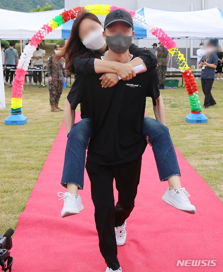 [증평=뉴시스] 강신욱 기자 = 7일 오후 충북 증평 육군 37사단에서 열린 가족 동반 입영식에 앞선 야외행사에서 한 입영장정이 '사랑하는 부모님 어부바길'에서 어머니를 업고 포토존으로 걸어오고 있다. 2022.06.07. ksw64@newsis.com&nbsp; 