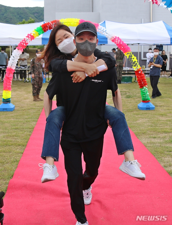 [증평=뉴시스] 강신욱 기자 = 7일 오후 충북 증평 육군 37사단에서 열린 가족 동반 입영식 야외행사에서 한 입영장정이 어머니를 업고 '사랑하는 부모님 어부바길'을 걷고 있다. 2022.06.07. ksw64@newsis.com 