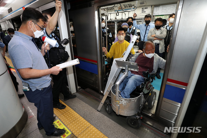 [서울=뉴시스] 백동현 기자 = 전국장애인차별철폐연대(전장연) 회원들이 7일 오전 서울 중구 회현역 승강장에서 장애인권리예산 보장을 촉구하는 출근길 선전전을 하고 있다. 2022.06.07. livertrent@newsis.com