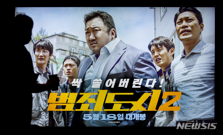 [서울=뉴시스] 정병혁 기자 = 영화 '범죄도시2'가 누적 관객수 930만명을 넘어선 7일 서울시내 영화관에 설치된 전광판 앞을 지나가고 있다. 영화진흥위원회에 따르면, '범죄도시2'는 현충일 연휴 나흘 간(3~6일) 169만3884명을 끌어모으며 누적 관객수 930만명을 넘겼다(932만3963명). 이는 코로나19 사태 이후 개봉한 영화 중 최고 흥행 기록이며, 국내 개봉 영화를 1000만명이 본 건 2019년 5월에 개봉한 '기생충'(1031만명) 이후 딱 3년만이다. 2022.06.07. jhope@newsis.com