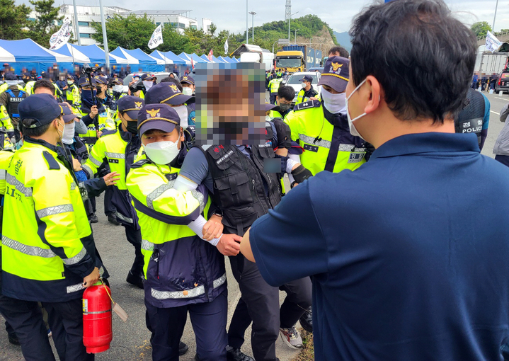 [부산=뉴시스] 부산경찰청은 8일 오전 부산 강서구 부산항 신항 교차로에서 집회를 준비하던 중 인근을 지나가던 컨테이너 운반 차량 2대의 진행을 가로막고 물병, 계란 등을 투척한 혐의를 받는 화물연대 노조원 2명을 현행범으로 체포했다고 밝혔다. (사진=부산경찰청 제공) 2022.06.08. photo@newsis.com   *재판매 및 DB 금지