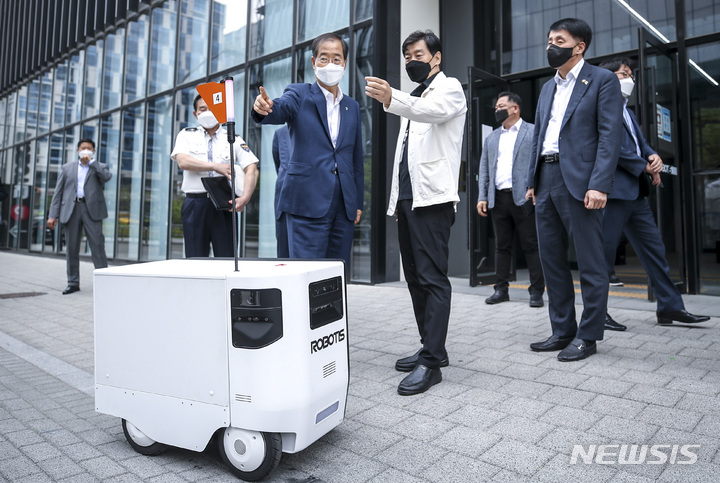 [서울=뉴시스] 정병혁 기자 = 한덕수 국무총리가 8일 오후 서울 강서구 규제샌드박스 승인기업인 로보티즈를 방문해 자율주행 배달로봇 '일개미'를 살펴보고 있다. 2022.06.08. jhope@newsis.com