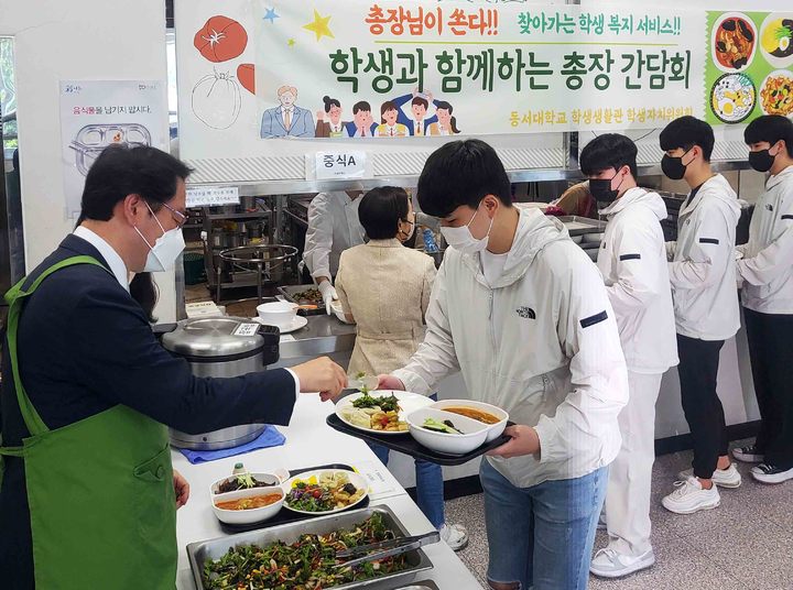 [부산=뉴시스] [부산=뉴시스] 장제국 동서대 총장이 10일 부산 사상구 대학 내 학생식당에서 기말고사 준비로 지친 학생들에게 점심식사를 대접하고 있다. (사진=동서대 제공)  *재판매 및 DB 금지