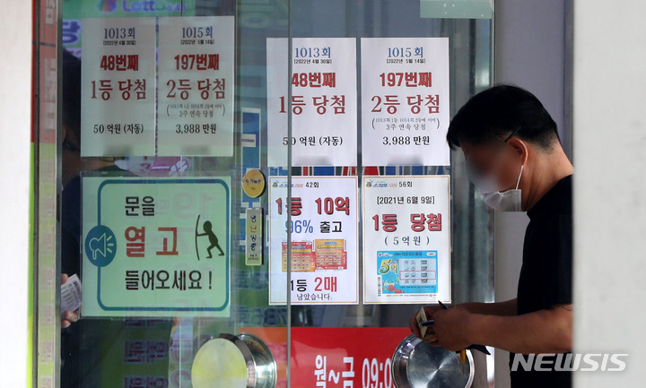 [서울=뉴시스] 추상철 기자 = 지난 13일 오후 서울의 한 로또 판매점에서 시민들이 로또를 구매하기 위해 줄 서 있다. 2022.06.13. scchoo@newsis.com